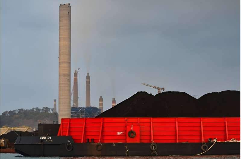 A barge carries coal to the dock next to the Suralaya coal-fired power plant in Cilegon, in Indonesia's Banten province